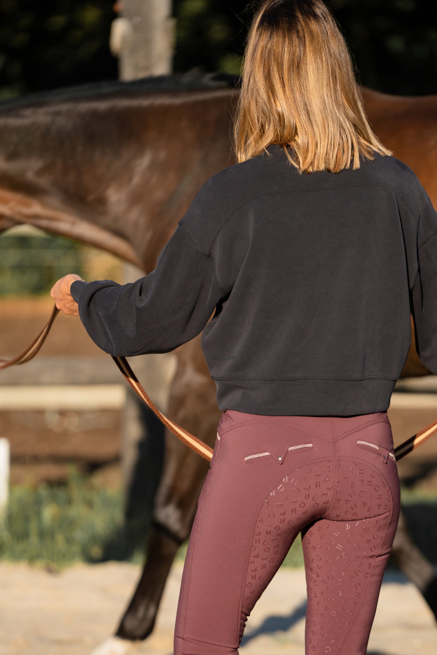 A person wearing maroon breeches with a stylish design on the back